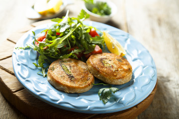 Salmon cakes with vegetables and arugula salad