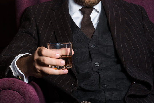 Closeup of serious businessman holding whiskey illustrate executive privilege concept