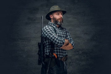 Bearded hunter holds a rifle.