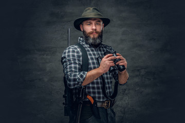 Bearded hunter holds a rifle.
