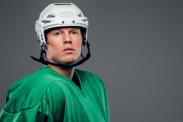Portrait of hockey player isolated on grey background.