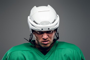 Naklejka premium Portrait of hockey player isolated on grey background.