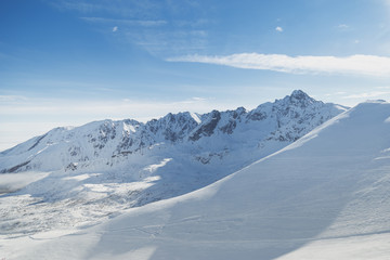 Fototapeta na wymiar Snowy slopes in winter mountains. Skiing resorts.