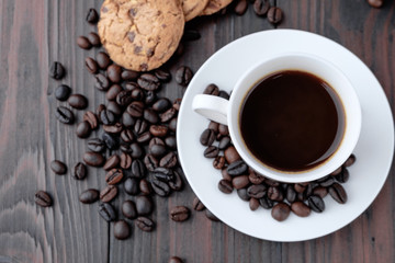 Coffee cup and coffee beans on wooden background