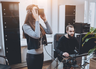 The young man with girlfriend plays a game at the office.