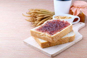 Bread with jam grape on wood background
