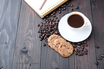 Coffee cup and coffee beans on wooden background