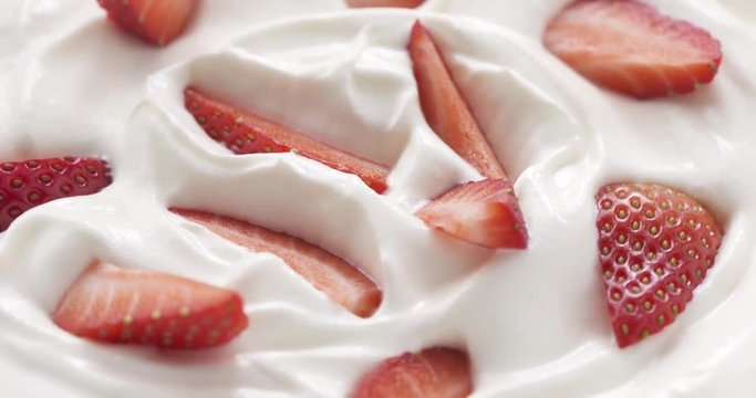 fresh sliced straberries in cream rotating background loopable, 4k prores footage