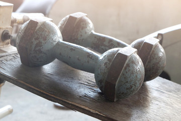 two old dumbbell on table with orange light..
