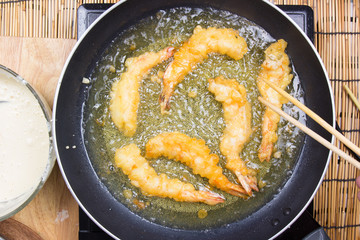 Chef frying shrimp Tempura with chopsticks