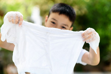 Boy washing cloth by his hand