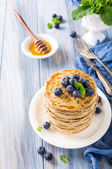Delicious pancakes with fresh blueberries on a wooden background. Healthy breakfast concept.