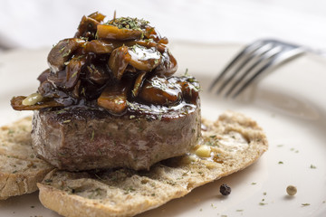 Beef Steak Fillet Covered with Mushroom Sauce on Toasted Baguette Bread with Melting Butter and Herbs