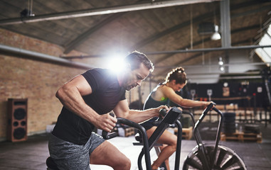 Obraz na płótnie Canvas Sportsmen working out hard on cycling machines