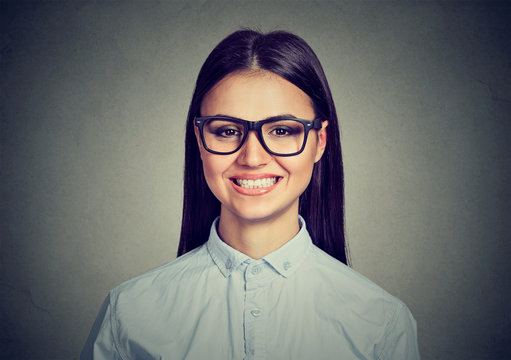 Closeup young woman, wearing eyeglasses, showing toothy smile