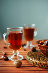 Bowl of dried dates on old wooden table with tea