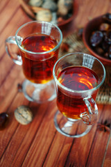 Bowl of dried dates on old wooden table with tea