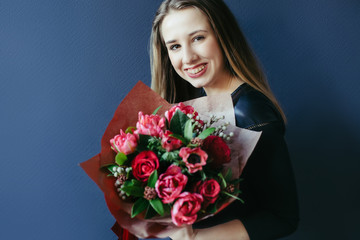 Cute girl with bouquet of red tulips.