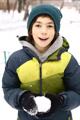 teen boy make snow ball on winter outdoors
