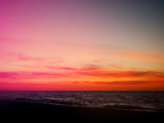 Fototapeta na wymiar Orange and pink sunset sky over the beach