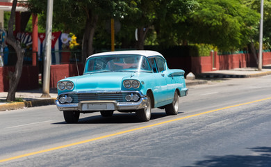 Blauer Oldtimer mit weißem Dach fährt auf der Straße durch Varadero Kuba - Serie Kuba Reportage