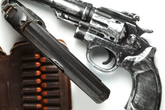 The automatic gun put beside with full load of old and dirty spare pistol bullet as background represent the weapon and bullet concept related idea.