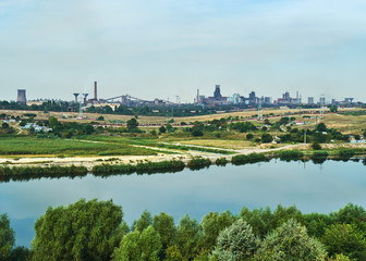 Industrial landscape. Metallurgical factory on the riverbank. Smoking chimneys of the plant. Ecological problem 