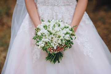 Obraz na płótnie Canvas Wedding bouquet of white flowers in bride's hands