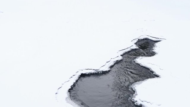 thawed patch of ice. Spring river has washed out the ice.
