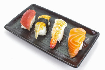 Japanese sushi raw seafood, vegetables and serving of cooked vinegared rice on white table background