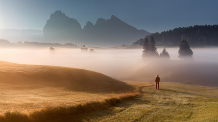 Beautiful girl looking at rising sun in South Tyrol Alps