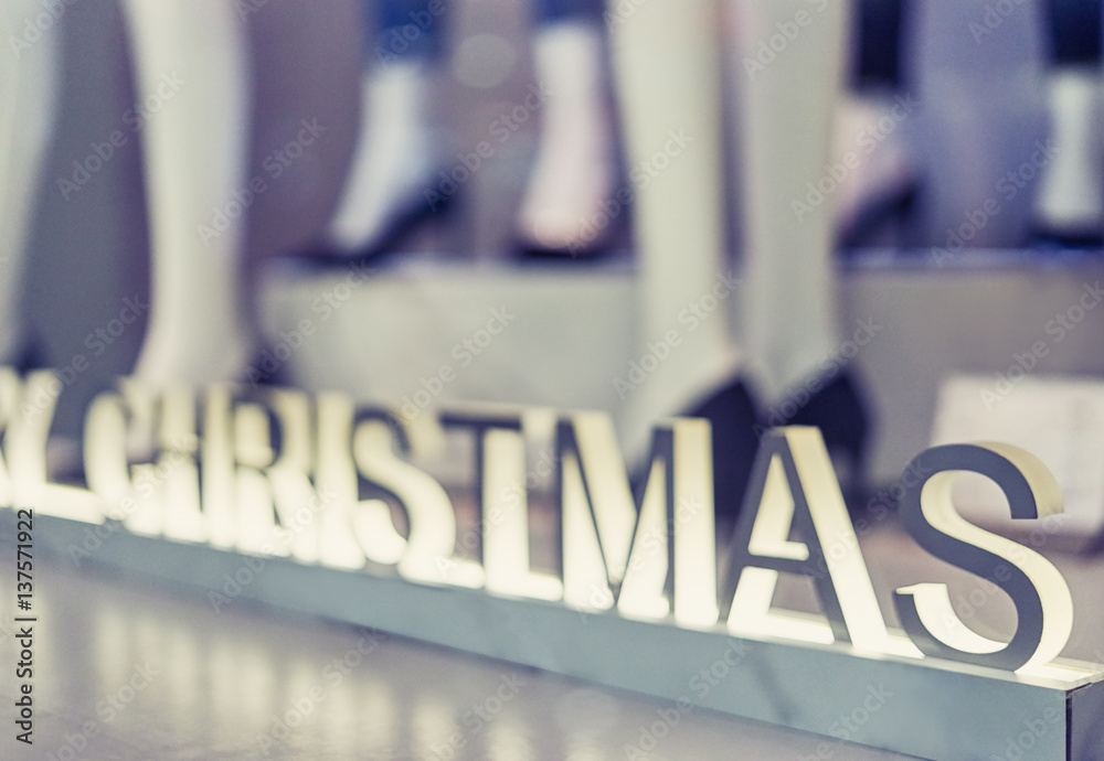 Wall mural blurred bright showcases clothing store decorated with white letters and christmas dummies in a mode