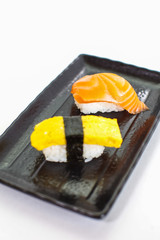 Japanese sushi raw seafood, vegetables and serving of cooked vinegared rice on white table background