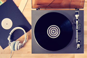 Gramophone with vinyl records  on a wooden table. Basic background for design
