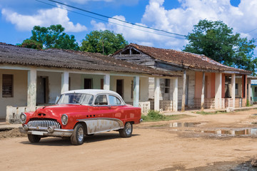 Rot weißer amerikanische Oldtimer parkt vor einem Haus in Santa Clara Kuba - Serie Kuba Reportage