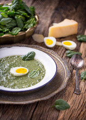 Spinach soup. Portion spinach soup with egg and cheese parmesan in retro style.