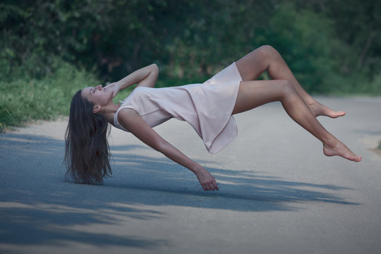 Levitation portrait of young woman on the road