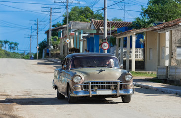 Brauner Oldtimer mit schwarzem Dach fährt durch die Vorstadt in Santa Clara Kuba - Serie Kuba Reportage