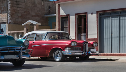 Amerikanischer roter Oldtimer parkt in der Seitenstrasse in Santiago de Cuba - Serie Kuba Reportage