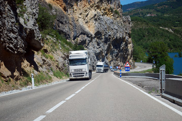 White trucks on the road through mountains