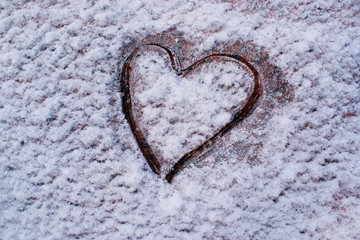 Abstract background of the surface of the granite in the snow with a painted heart