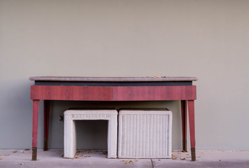 Old furniture against a wall.  Table and wicker