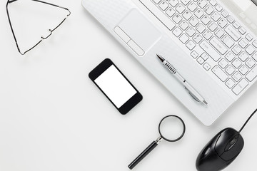 Top view accessories business office desk.mobile phone,laptop,mount,eyeglasses,magnifier,pen on white office desk with copy space.