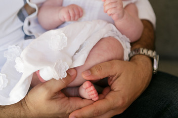 Father holding a small daughter in a dress