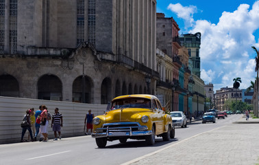 Kuba amerikanische gelber Oldtimer fährt auf der Hauptstrasse von Havanna City in Kuba- Serie Kuba Reportage
