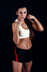 Fototapeta na wymiar Angry fitness girl ready for fight on black background.