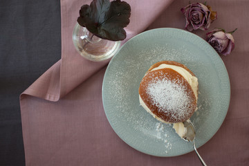 Traditional Swedish semla on a plate with a spoon closeup from above 