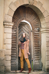Fototapeta na wymiar beautiful girl near old wooden gate in the city