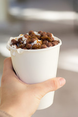 Hand holding  late coffe to go with whiped cream on it