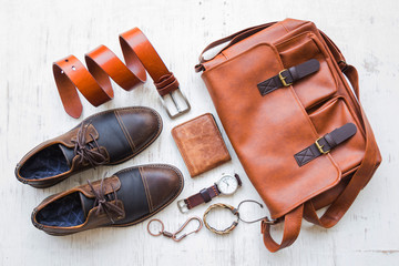 Men's casual outfits with leather accessories on white rustic wooden background, beauty and fashion concept